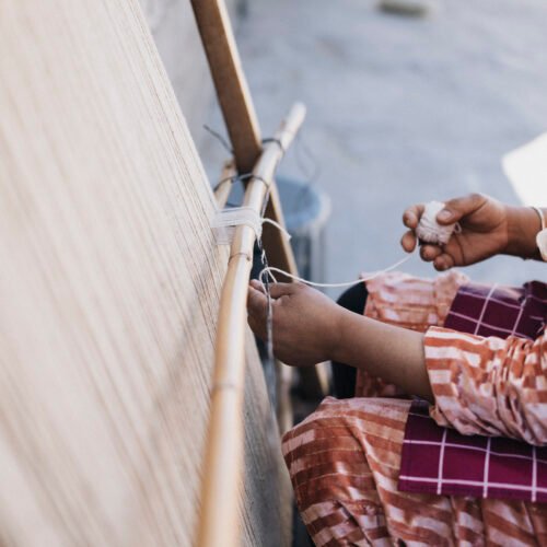 pessoa a tecer num tear tradicional